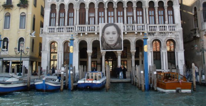 Ein Bild von Venedig. Im Vordergrund sind Gondeln im Wasser zu sehen.